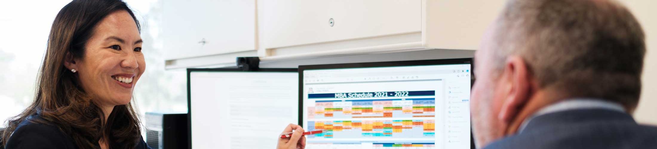 Woman showing computer screen to colleague