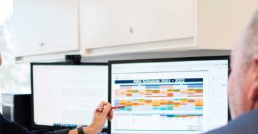 Woman showing computer screen to colleague