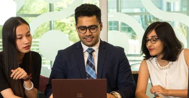 young businesspeople looking at computer