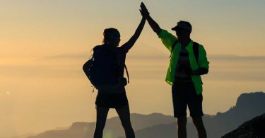 Man and woman celebrate on mountaintop