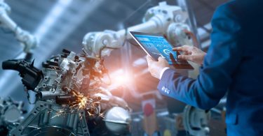 Futuristic manufacturing robot with person holding tablet