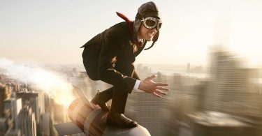 Businessman riding rocket over city