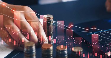 Businessman counting money with downward sloping lines