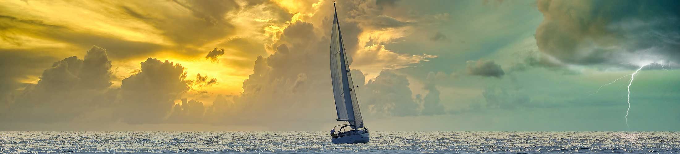 Ship sailing toward sunrise and storm