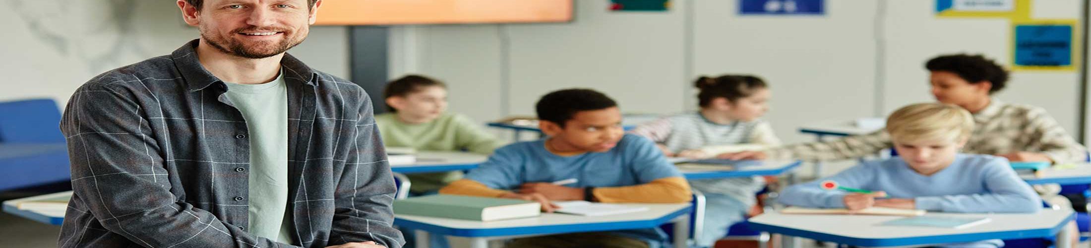 Male teacher sitting on desk