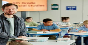 Male teacher sitting on desk