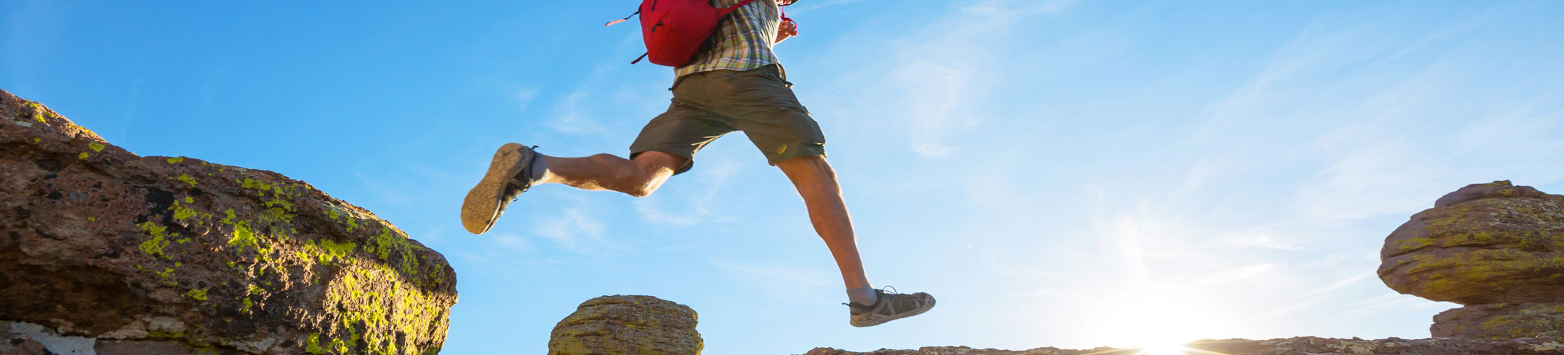 Man jumping over larger rocks