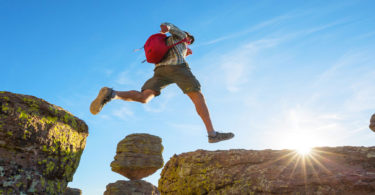 Man jumping over larger rocks