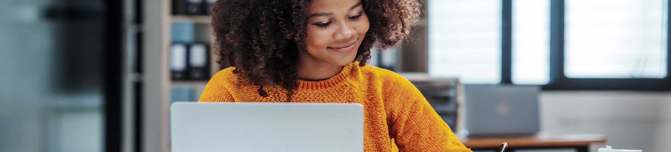 Woman sitting desk writing paper