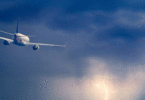 Plane flying lightning ocean