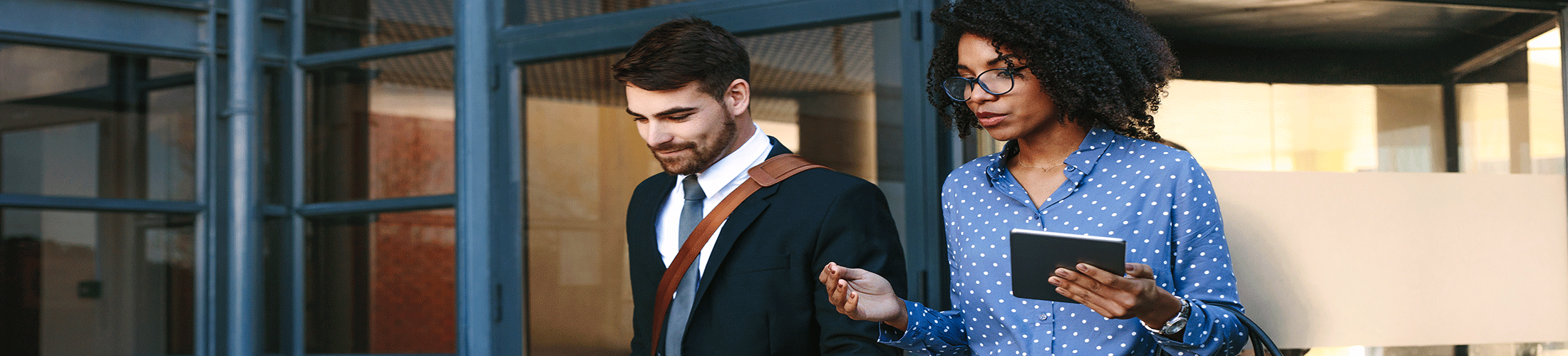 Man and woman walking out of an office building